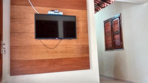 a flat screen tv on the wall of a room at Estancia Vale das Flores in Pacoti