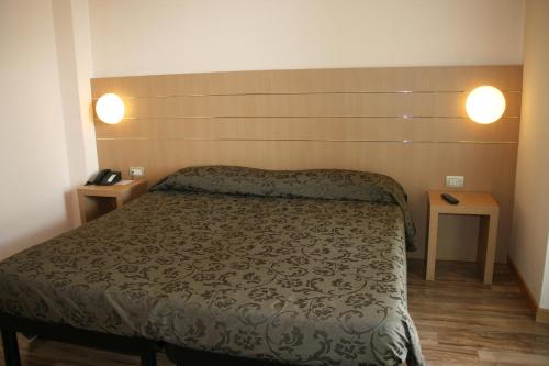 a bedroom with a bed and two tables at Albergo Nardini in Lentate sul Seveso