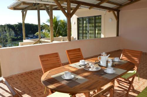 comedor con mesa y sillas en el patio en Riverside Holiday Home en Grande Rivière Sud Est