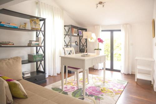 una sala de estar con un escritorio blanco en una habitación en Casa do Ácer, en São Vicente Ferreira