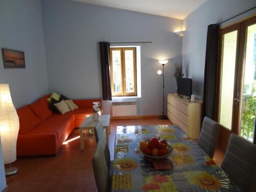 a living room with a couch and a table with a bowl of fruit at Le Moulin Des Ocres in Apt
