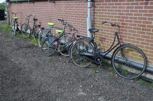 uma fila de bicicletas estacionadas contra uma parede de tijolos em Your Cozy Waggon at the Cows' Paradise em Amesterdão