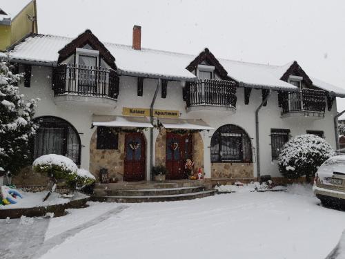 una casa con nieve en el suelo delante de ella en Kaiser Apartman, en Hévíz
