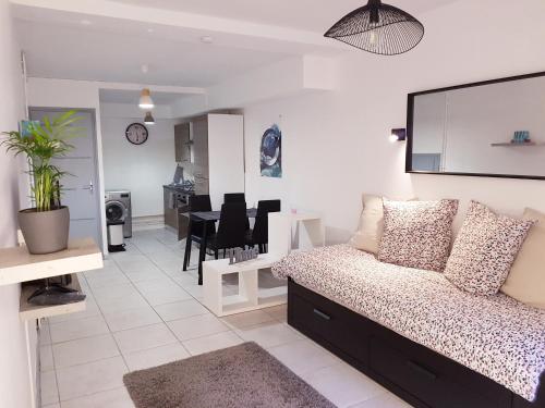 un salon avec un canapé et une salle à manger dans l'établissement Studio hyper centre, tout confort, à Lourdes