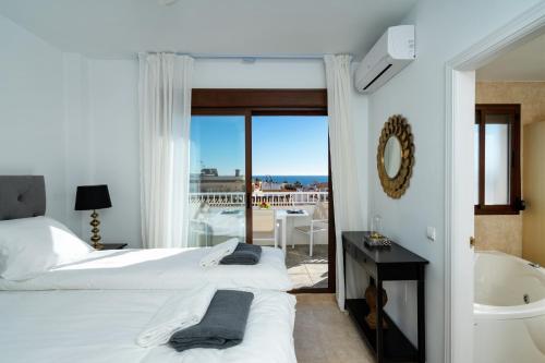 ミハス・コスタにあるPool Penthouse in La Cala de Mijas Ref 19のベッドルーム1室(ベッド2台、バスタブ付)、バルコニーが備わります。
