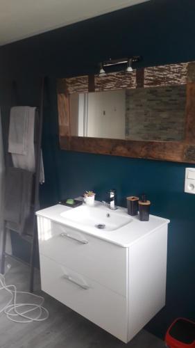baño con lavabo blanco y pared azul en Taillefer, en Saint Paul de Loubressac