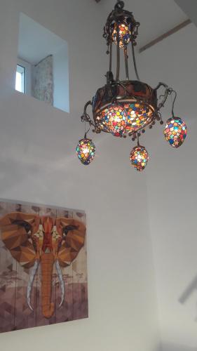 a chandelier hanging from a ceiling with a painting at Taillefer in Saint Paul de Loubressac