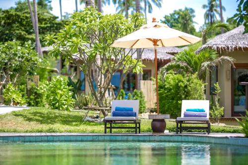 two chairs and an umbrella next to a swimming pool at Sea Dance Resort in Choeng Mon Beach