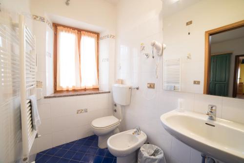 La salle de bains blanche est pourvue de toilettes et d'un lavabo. dans l'établissement Hotel Appennino, à Fiumalbo