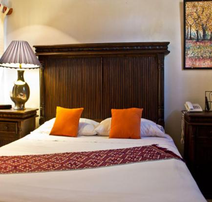 a bedroom with a bed with orange pillows and a lamp at Casa Madonna in Guadalajara