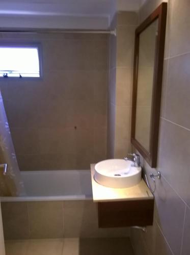 La salle de bains est pourvue d'un lavabo, d'un miroir et d'une baignoire. dans l'établissement SOLAR DEL ABASTO, à Buenos Aires