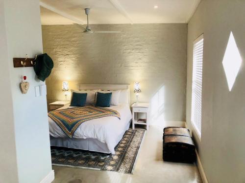 a bedroom with a white bed and a wall at The Lemon Tree in Prince Albert