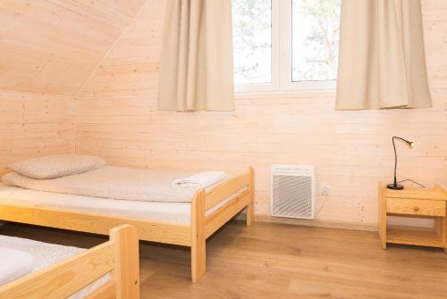 オシフィエンチムにあるOld Tree Village & Restaurantのベッドと窓が備わる小さな客室です。