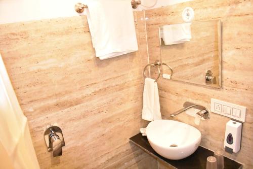 Hotel Shagun Residency في ماثورا: حمام مع حوض ومرآة
