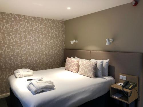 a hotel room with a bed with towels on it at Edgbaston Park Hotel Birmingham in Birmingham