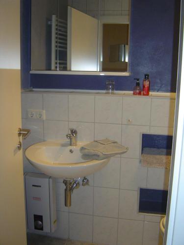a bathroom with a white sink and a mirror at ApartmentHotel Vollumen in Redwitz an der Rodach