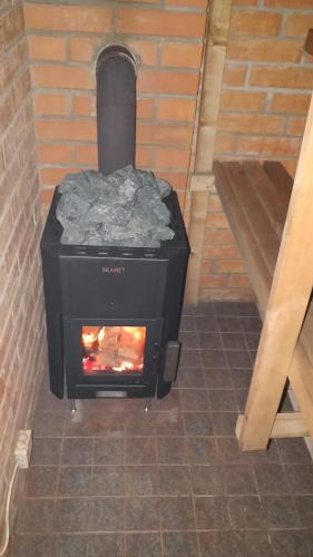 a black stove with a fire in it at Poodli Holiday Home in Sõru