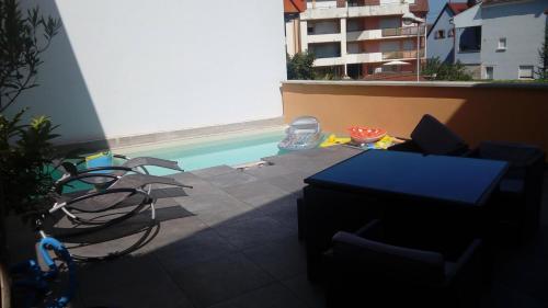 - une vue sur la piscine avec des chaises et une table dans l'établissement Maison / villa complète à 5 minutes de Colmar, à Ingersheim