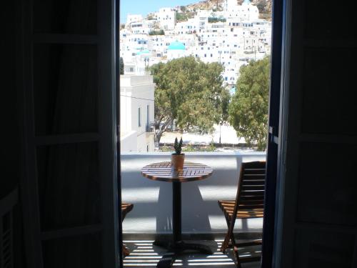 um quarto com uma mesa e vista para a cidade em Armonia Pension em Chora, Ios