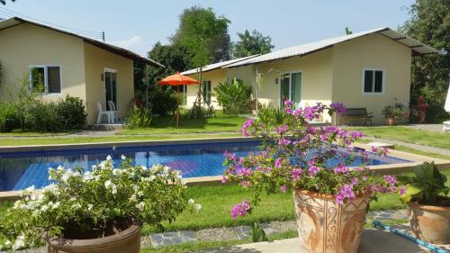 a villa with a pool and a house at Longan Tree in Ban Nam Thong