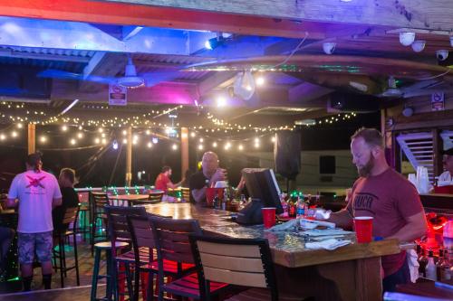 a group of people sitting at a bar in a restaurant at Casa Verde Hotel - Steps to the Beach, Pool, Restaurant & Bar in Rincon