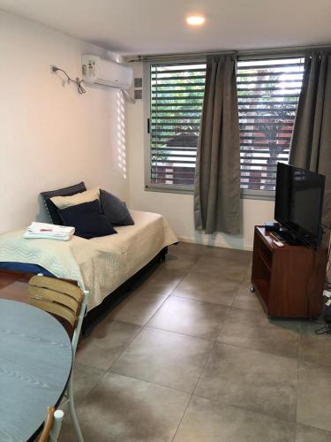1 dormitorio con 1 cama y TV. en Residencia Pasco en Rosario