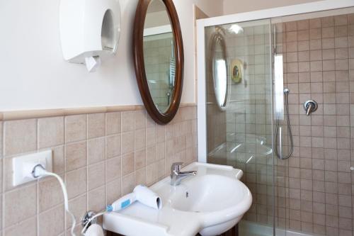 a bathroom with a sink and a shower with a mirror at Affittacamere Libano in Torre del Lago Puccini