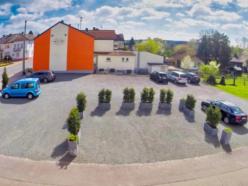 a parking lot with cars parked in front of a building at Hotel Maurer in Saarwellingen