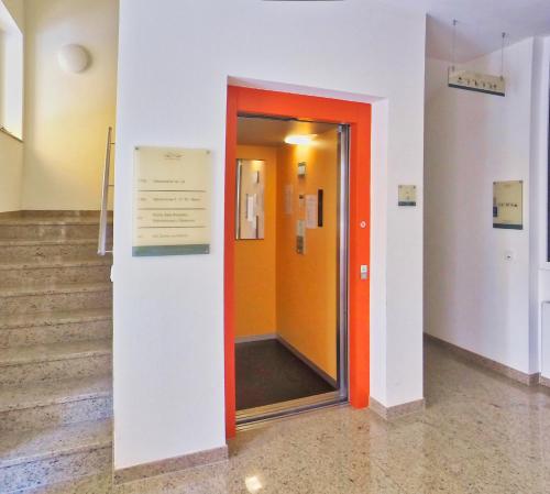 a hallway with an orange door in a building at Hotel Maurer in Saarwellingen