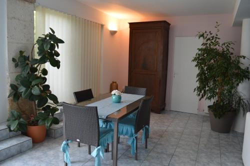 a table and chairs in a room with plants at Les remparts d'Angoulême in Angoulême