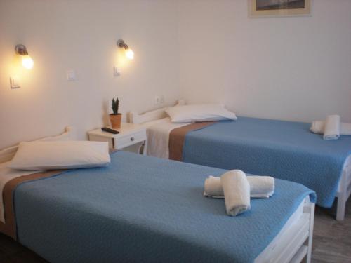 a room with two beds with towels on them at Armonia Pension in Ios Chora
