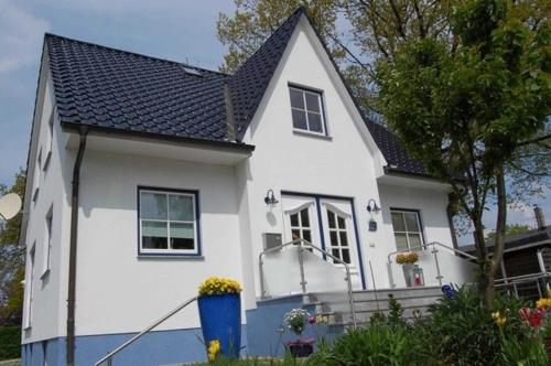 una casa blanca con techo negro en Ferienwohnung Schuett _ Objekt 259, en Rostock