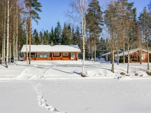 una casa nella neve davanti a una casa di Holiday Home Kivitasku by Interhome a Kallionkieli