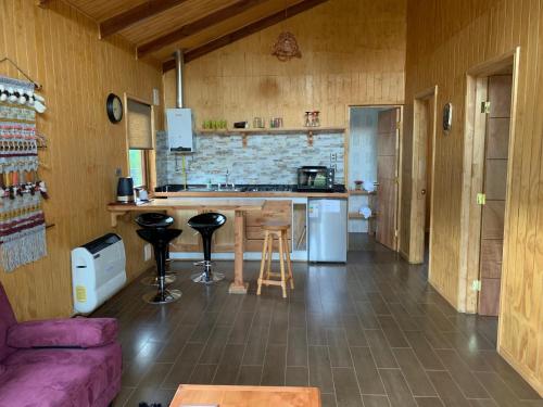 a kitchen with a purple couch in a room at Cabañas Cerro Huemules in Coihaique