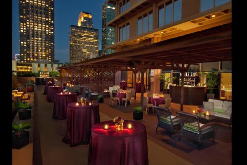a row of tables on a rooftop patio with lit candles at Fairmont Dallas in Dallas