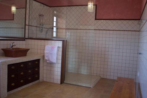 een betegelde badkamer met een wastafel en een douche bij Quiet Rural House Ten Minutes From The Beach in Puerto del Rosario