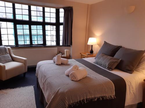 a bedroom with a bed with two stuffed animals on it at The Crown at Wells, Somerset in Wells