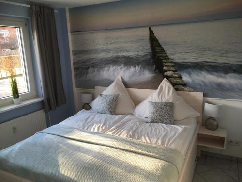 ein Schlafzimmer mit einem Bett mit einem Gemälde des Ozeans in der Unterkunft Kleine Sonne in Grömitz