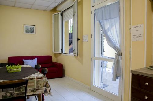 a room with a table and a red couch and a window at Residence Daniele in Bellaria-Igea Marina