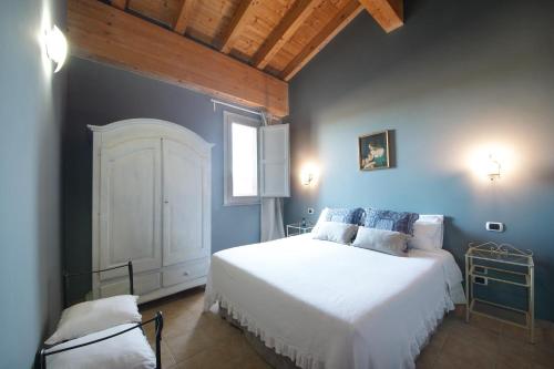 a bedroom with a white bed and a blue wall at Casa di Melo - Organic Country Hotel in Cassibile