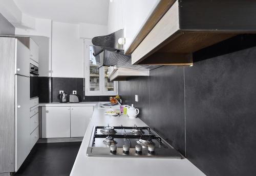 Il comprend une cuisine équipée d'un four et de plaques de cuisson. dans l'établissement Sunlight Properties - Parisian Bleu - Calm with Sea View, à Nice