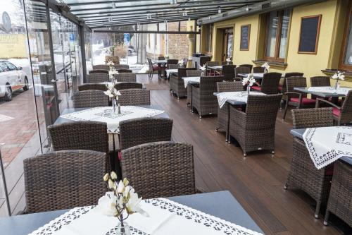 un restaurante vacío con mesas y sillas con flores. en Penzion Rosenthal en Ružindol