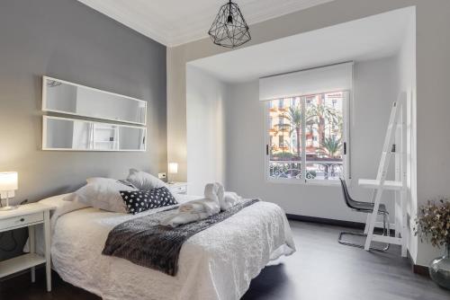 1 dormitorio con cama, escritorio y ventana en La Casa de los Espejos, en Alicante