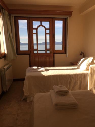 a hotel room with two beds with towels on them at Balcones del Beagle Apart in Ushuaia