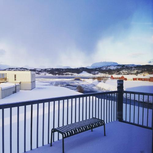 a bench on a balcony with snow on the ground at Bjugn Hotell in Botngard