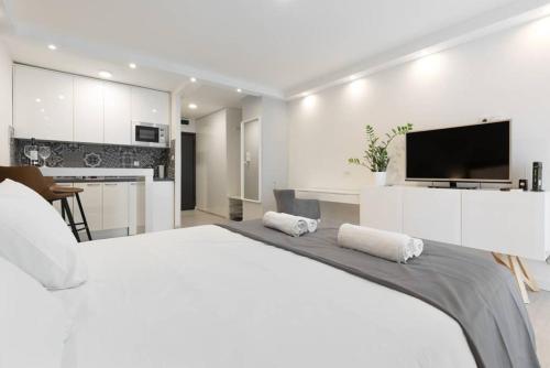 1 dormitorio blanco con 1 cama grande y cocina en Penthouse "Sky 17" s balkonom i besplatnim parkingom, en Zagreb