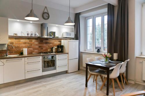 a kitchen with a table and chairs and a refrigerator at Cichy apartament w centrum Krakowa Salwator in Krakow
