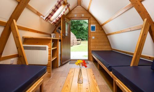 a room with benches and a table in a tiny house at Woodclose Park in Kirkby Lonsdale