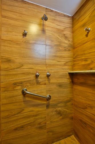 a shower with a wooden wall with a metal handle at ARCUS Hotel By Atlântica in Aracaju