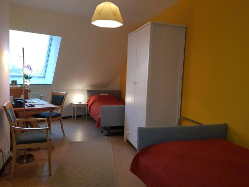 a bedroom with two beds and a table and a cabinet at Haus Aja Textor-Goethe in Frankfurt